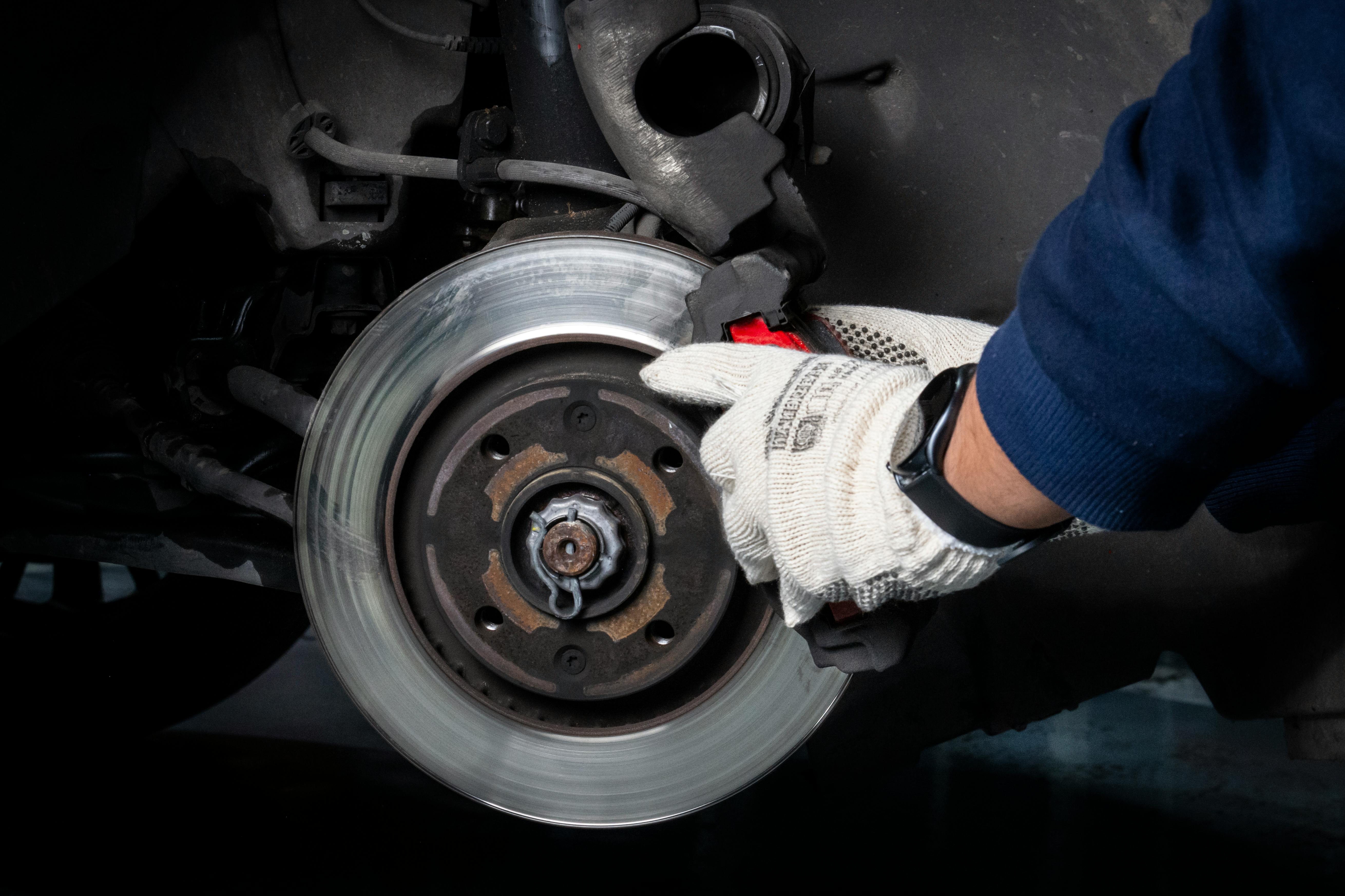 mechanic inspecting vehicle brakes